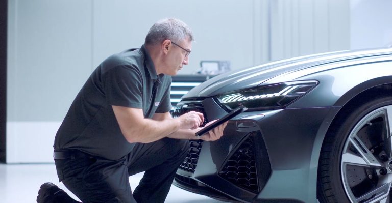 Audi javítás laptoppal, overállos férfi által.